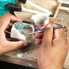 a person is working on some kind of crafting project with wood and glass beads