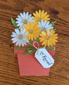 a flower pot with daisies in it and a tag hanging from the top that says happy mother's day