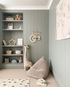 a baby's room with bookshelves, stuffed giraffe and other toys