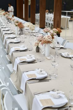 the table is set with white linens and silverware for an elegant wedding reception