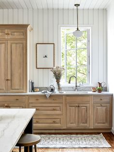 an image of a kitchen setting with wood cabinetry and white paint on the walls