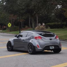 a gray sports car driving down the street