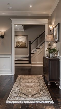 a living room filled with furniture and a rug on top of a hard wood floor