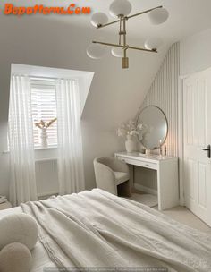 a bedroom with a white bed, dresser and mirror in it's corner next to a window