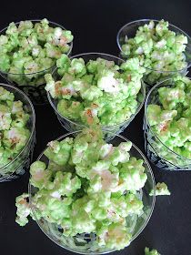 small bowls filled with green and white candy on top of a black tablecloth covered surface