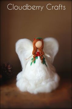 a white angel figurine sitting on top of a wooden table