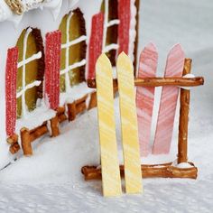 a small house made out of wood and painted red, white and yellow in the snow