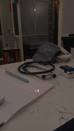 an open notebook with a stethoscope on top of it next to other items