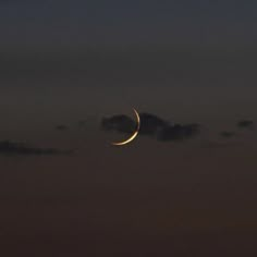 the moon is shining in the night sky with clouds and some dark blue hues