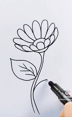 someone is drawing a flower with a marker