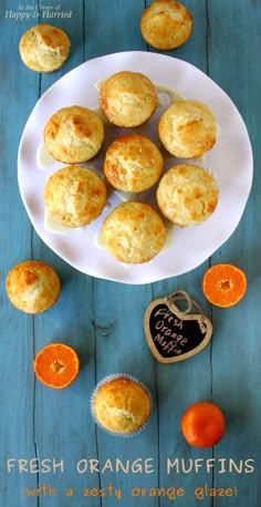 fresh orange muffins on a white plate with an orange slice