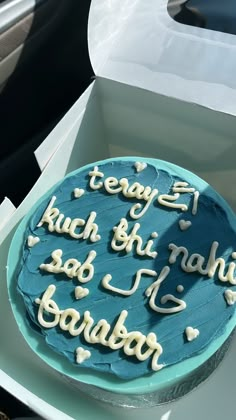 a blue cake with writing on it in a box