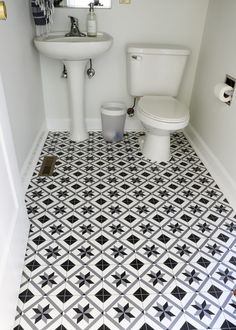 a white toilet sitting next to a sink in a bathroom under a mirror on top of a tiled floor