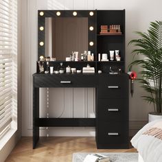 a black vanity with lights on it next to a bed and potted palm tree