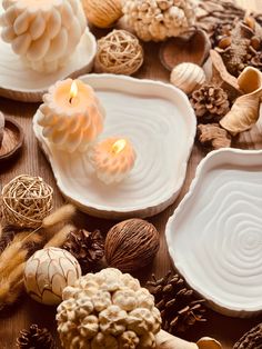 several different types of candles and shells on a table