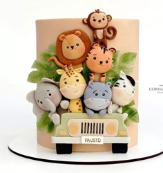 a cake decorated with animals on top of a car