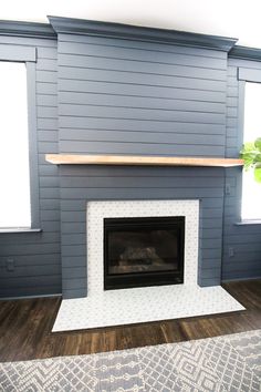 a fireplace in a living room with blue walls and wood flooring on the side