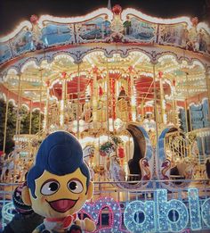 the mascot is standing in front of a merry go round