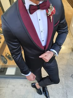 a man in a tuxedo is posing for the camera