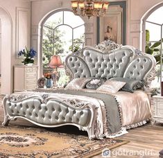 a bedroom with an ornate bed and chandelier in the corner, along with a rug on the floor