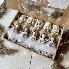 an open box filled with eggs on top of a wooden floor next to feathers and lights