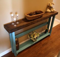 a wooden table topped with a vase filled with flowers next to a stuffed animal on top of it