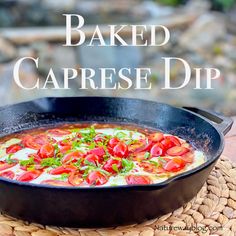 baked caprese dip in a cast iron skillet on a wicker place mat