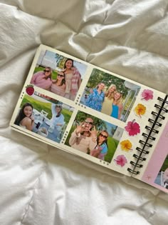 an open notebook with pictures of people on it sitting on a white bed sheet in front of the camera