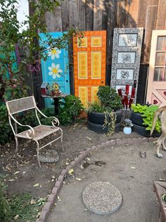 an outdoor area with chairs, plants and pictures on the fenced in side yard