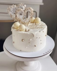 a white cake with gold decorations on top