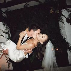 a bride and groom kissing in front of a candle lit area at their wedding reception