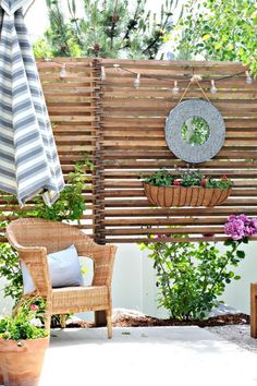 an outdoor patio with potted plants and umbrellas hanging from the side of it