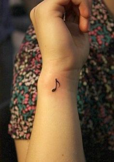 a woman's arm with a small tattoo on her left wrist and the word love written