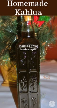 a bottle of homemade kahlua sitting on a table next to a christmas tree