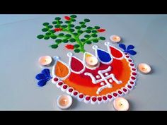 some candles are sitting on a table next to a decorated cake with flowers and leaves