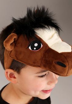 a young boy wearing a brown horse mask