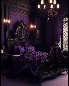 a bed with purple sheets and pillows in a dark room next to a chandelier