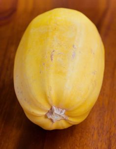 a yellow fruit sitting on top of a wooden table