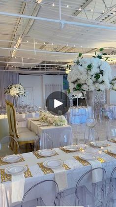 a table set up for a wedding with white flowers and gold napkins on it