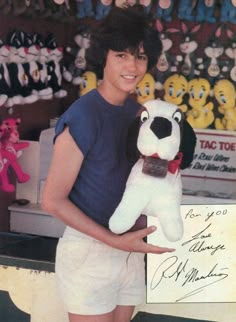 a young man holding a stuffed animal dog