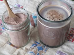 two jars filled with different types of food on top of a quilted table cloth