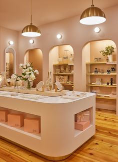 the interior of a beauty shop with lots of counter space and flowers in vases