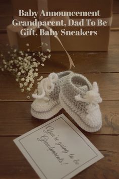 a baby announcement card with a pair of slippers next to it