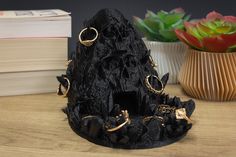 a black rock with gold rings on it next to some books and a potted plant