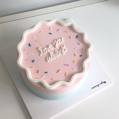 a pink cake with sprinkles that says love you always