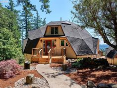 a small house with a walkway leading to the front door and steps up to it