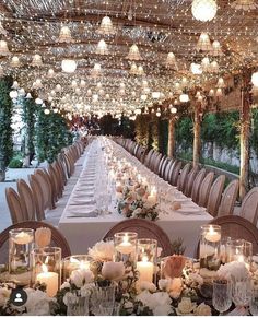 a long table is set up with candles and centerpieces for an elegant dinner