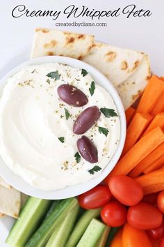 hummus, carrots, and celery on a plate with pita bread