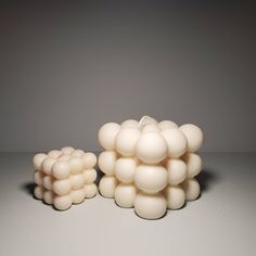 a group of white balls sitting on top of a table next to each other in front of a gray background