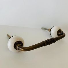 two white knobs are attached to a wooden handle